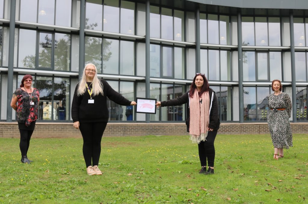 Maria Watson, Student Wellbeing and Tutorial Co-ordinator, East Coast College student ambassadors Chelsea Tomkinson and Chloe Eden and Catherine Duffield, Student Services Manager, holding the Carer Friendly Tick Award outside the college. 