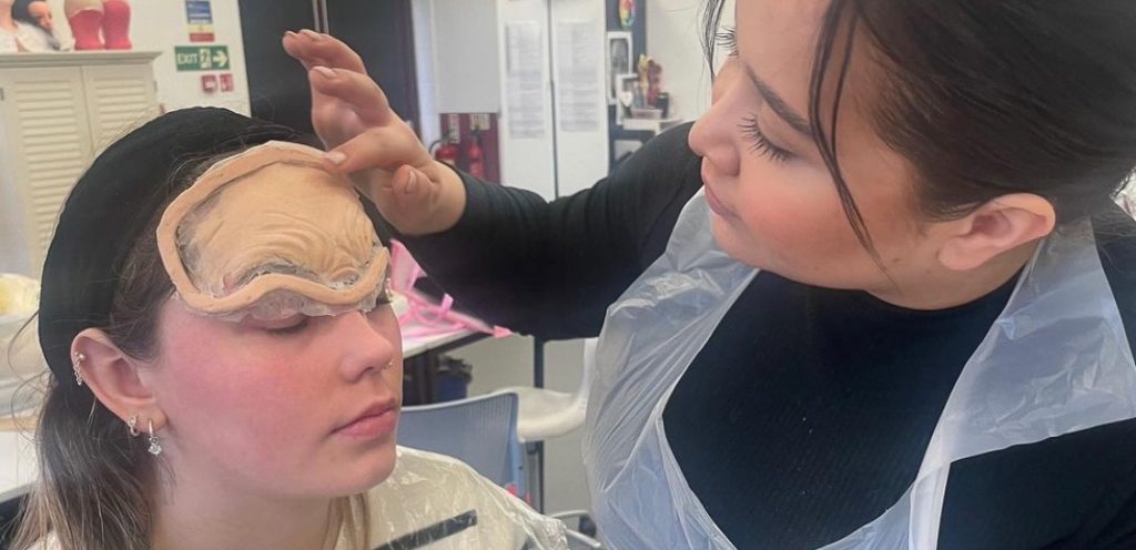 East Coast College Level 4 media make-up student applying special effects make-up to a client  